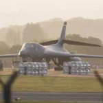 Cinco homens foram presos neste domingo (27) nas proximidades da RAF Fairford, no sudoeste da Inglaterra, durante uma operação que levou as autoridades britânicas a declarar um grande incidente de segurança na região. A polícia informou que os suspeitos foram inicialmente detidos por possíveis crimes relacionados à legislação sobre explosivos e, posteriormente, passaram a ser investigados sob suspeita de preparação de um ato terrorista. A operação ocorreu na região de Whelford, próxima à base aérea de Fairford, instalação utilizada pela Força Aérea dos Estados Unidos. O episódio provocou uma grande mobilização das forças de segurança e a retirada preventiva de moradores de dezenas de imóveis. Segundo a Polícia de Gloucestershire, a ocorrência começou durante a madrugada, quando as autoridades receberam uma informação sobre três veículos suspeitos que estariam seguindo em direção à RAF Fairford. Policiais armados foram enviados ao local e efetuaram as cinco prisões. Três veículos passaram por análise de especialistas em explosivos Depois das prisões, uma área de segurança foi estabelecida ao redor dos veículos. O perímetro chegou a aproximadamente 400 metros, enquanto uma unidade especializada do Exército britânico realizava exames nos automóveis. A preocupação das autoridades levou à retirada preventiva de moradores que vivem na área próxima aos veículos. Aproximadamente 85 residências foram evacuadas durante a operação. A polícia informou que um centro de lazer próximo foi disponibilizado para receber pessoas que não tinham condições de permanecer com familiares ou amigos enquanto os trabalhos de segurança eram realizados. A Polícia de Gloucestershire afirmou que a ocorrência estava contida e pediu que a população evitasse especulações enquanto a investigação prosseguia. Prisões ocorreram durante a madrugada De acordo com o comunicado oficial, a polícia recebeu a informação sobre os veículos por volta de 0h45 deste domingo. Equipes armadas chegaram à região de Whelford e prenderam cinco homens. Inicialmente, eles foram levados sob custódia por suspeita de infrações previstas na Lei de Explosivos. Posteriormente, os investigadores passaram a considerar também a hipótese de preparação de um ato terrorista, conforme previsto pela legislação britânica. A unidade de polícia antiterrorista assumiu a condução da investigação. Até o momento, as autoridades não divulgaram detalhes completos sobre a identidade dos suspeitos, uma possível motivação ou o que exatamente teria sido encontrado nos veículos. Base aérea tem ligação com operações militares dos Estados Unidos A RAF Fairford é uma instalação militar britânica que também possui importância estratégica para os Estados Unidos. A base tem sido utilizada por aeronaves militares americanas e, segundo relatos publicados neste domingo, passou a desempenhar um papel importante nas operações dos EUA relacionadas ao conflito com o Irã. A localização estratégica da instalação aumenta a relevância do episódio para as autoridades de segurança britânicas e americanas. A proximidade entre Whelford e a base também explica a preocupação das autoridades em estabelecer rapidamente um perímetro de segurança e retirar moradores da área. Apesar da operação, a polícia britânica não confirmou que os suspeitos tenham conseguido chegar à instalação militar. Investigação ainda tenta esclarecer o objetivo dos suspeitos Um dos principais pontos ainda em investigação é determinar por que os três veículos estavam se deslocando em direção à RAF Fairford e qual seria a finalidade da ação. A prisão por suspeita de preparação de um ato terrorista não significa, por si só, que um ataque tenha ocorrido ou que os investigadores já tenham estabelecido definitivamente a motivação dos suspeitos. As autoridades continuam analisando os veículos e outras possíveis evidências para determinar a natureza da ocorrência. A Polícia de Gloucestershire também destacou que o trabalho está sendo realizado em coordenação com outras forças e órgãos nacionais de segurança. Moradores foram retirados por precaução A evacuação de aproximadamente 85 casas foi uma das principais consequências imediatas da operação. A medida foi adotada enquanto especialistas em explosivos examinavam os veículos, diante da possibilidade de que algum material perigoso estivesse presente. A polícia informou que a decisão tinha caráter preventivo e que a ocorrência estava sob controle. O objetivo era permitir que os especialistas trabalhassem com uma distância de segurança adequada da população. Moradores foram direcionados para um centro de lazer próximo ou orientados a permanecer temporariamente com familiares e amigos. Forças britânicas mantêm operação de segurança A operação envolveu policiais armados, equipes especializadas em explosivos e outros serviços de emergência. Segundo as autoridades, os procedimentos utilizados fazem parte dos planos preparados para situações classificadas como grandes incidentes. A Polícia de Gloucestershire afirmou que sua prioridade era proteger a comunidade local e permitir que os trabalhos de investigação e segurança fossem realizados o mais rapidamente possível. As autoridades também pediram aos moradores que acompanhassem somente os canais oficiais para obter informações sobre a situação. Caso ocorre em meio a preocupações de segurança O episódio acontece em um período de atenção reforçada das autoridades britânicas para possíveis ameaças contra instalações militares e outros locais considerados estratégicos. Entretanto, neste momento, a polícia ainda não apresentou publicamente uma conclusão sobre a motivação dos cinco homens ou confirmou qualquer vínculo específico com governos ou organizações estrangeiras. Também não foi confirmado oficialmente se havia explosivos nos veículos. Os exames realizados pela unidade especializada do Exército são justamente parte do processo para esclarecer essa questão. O que se sabe até agora Até o momento, as autoridades britânicas confirmaram: Cinco homens foram presos em Whelford; As prisões ocorreram depois de uma denúncia envolvendo três veículos suspeitos; Os veículos estavam sendo examinados por especialistas em explosivos do Exército; Foi estabelecido um perímetro de segurança de aproximadamente 400 metros; Cerca de 85 residências foram evacuadas; A investigação é conduzida pela polícia antiterrorista; Os suspeitos permanecem sob custódia; As autoridades ainda investigam a natureza e a motivação da ocorrência. A investigação continua, e novas informações deverão ser divulgadas pelas autoridades britânicas à medida que os exames dos veículos e os interrogatórios dos suspeitos avancem.